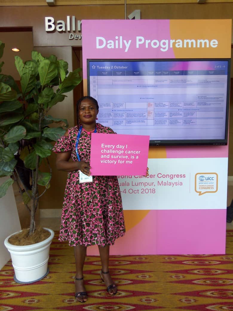 bcighana's tweet photo. Our 6 year #breastcancersurvivor Miss Joyce (post mastectomy) with a placard at the @uicc #2018WCC world cancer congress in Malaysia. #BreastCancerMonth #BreastCancer @Delta @NicolaManning1 @KDMcGhee @JulieMcCrossin @ABCGlobalAll @shewie268 https://t.co/Q07YcXGznm