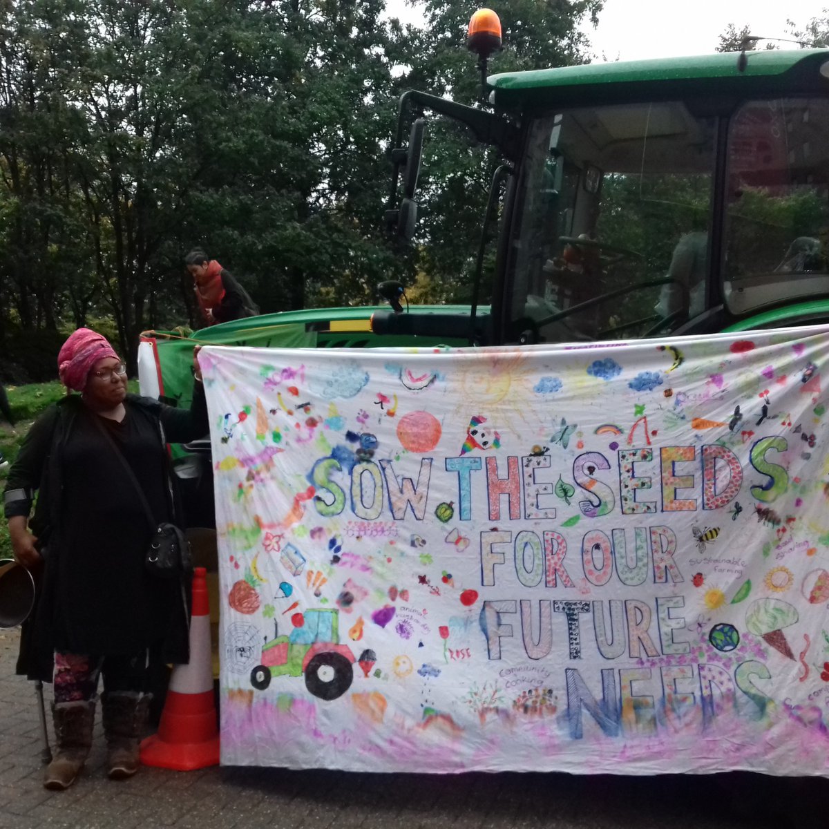 Our beautiful banner with Dee and the tractor!  It says SOW THE SEEDS FOR OUR FUTURE NEEDS! <a href="/Didara/">Deirdre⭐Dee⭐Woods</a> @LandworkersUK <a href="/sabineegoodwin/">Sabine Goodwin</a> @london_grown <a href="/voicesthatSHAKE/">Voices that Shake!</a> @squashliverpool <a href="/UKSustain/">Sustain</a>