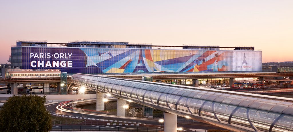ParisAeroport's tweet photo. Paris-#Orly is changing! The 3200sqm of the facade of the South Terminal is decorated with a monumental fresco by the Italian artist @Ray_Oranges, highlighting the airport's ongoing transformation. #art #airport #RayOranges https://t.co/V07W7qosdN