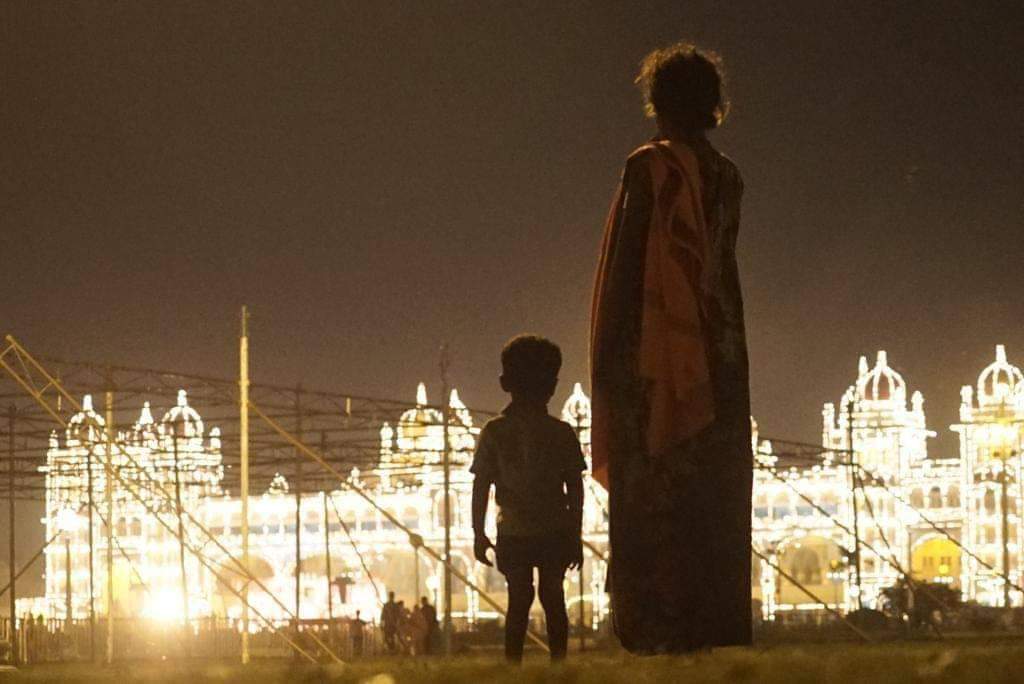 Homeless mother and child watching illuminated Mysore palace. Brilliant picture by ace photographer Nethraraju. #MysuruDasara2018