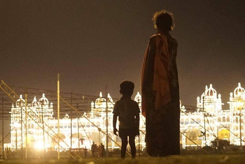 Homeless mother and child watching illuminated Mysore palace. Brilliant picture by ace photographer Nethraraju. #MysuruDasara2018