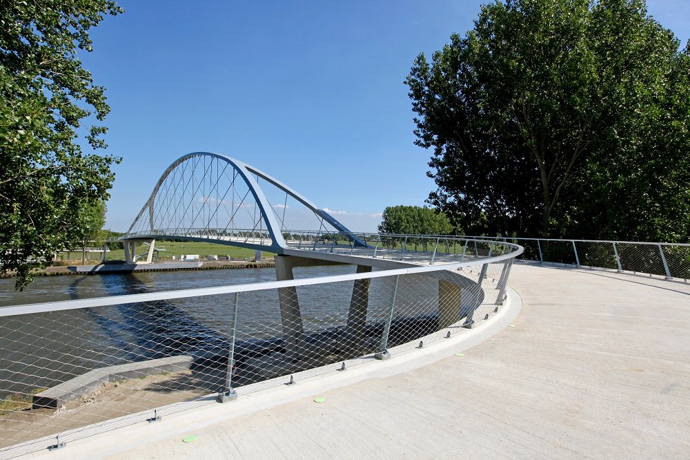 VerkeerInBeeld's tweet photo. Sinds begin augustus kunnen fietsers en voetgangers via de nieuwe boogbrug bij Nigtevecht het Amsterdam-Rijnkanaal over. Voor de ontwerpers van @ipvDelft draaide het bij dit project vooral om ruimtelijke inpassing, gebruikerscomfort en transparantie. 

https://t.co/hNI2jKcjvr https://t.co/NIGDU8wuRt