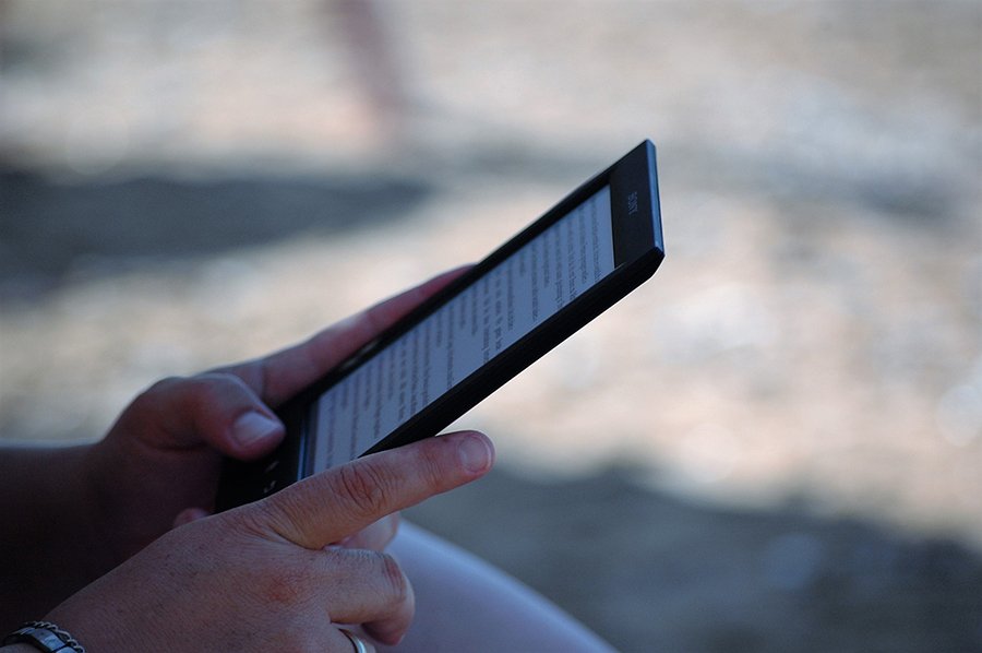 a person holding an e-reader in their hand.