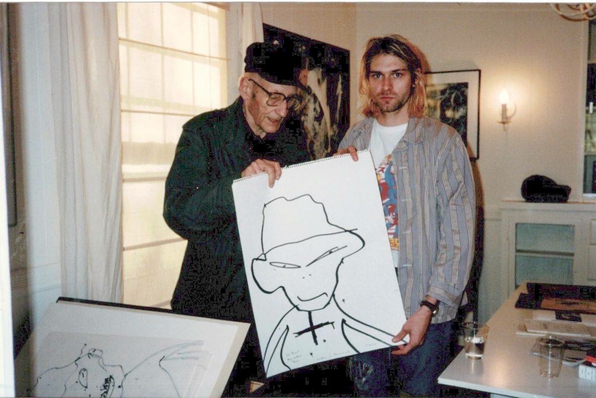 KurdtCobain1967's tweet photo. [New photo]
William Burroughs giving a “self-portrait” an alien with a hat and a cross on his chest to Kurt.

Never before had kurt been seen behaving like a happy fan to meet someone famous.

October 20th 1993 https://t.co/ReolCt6jma