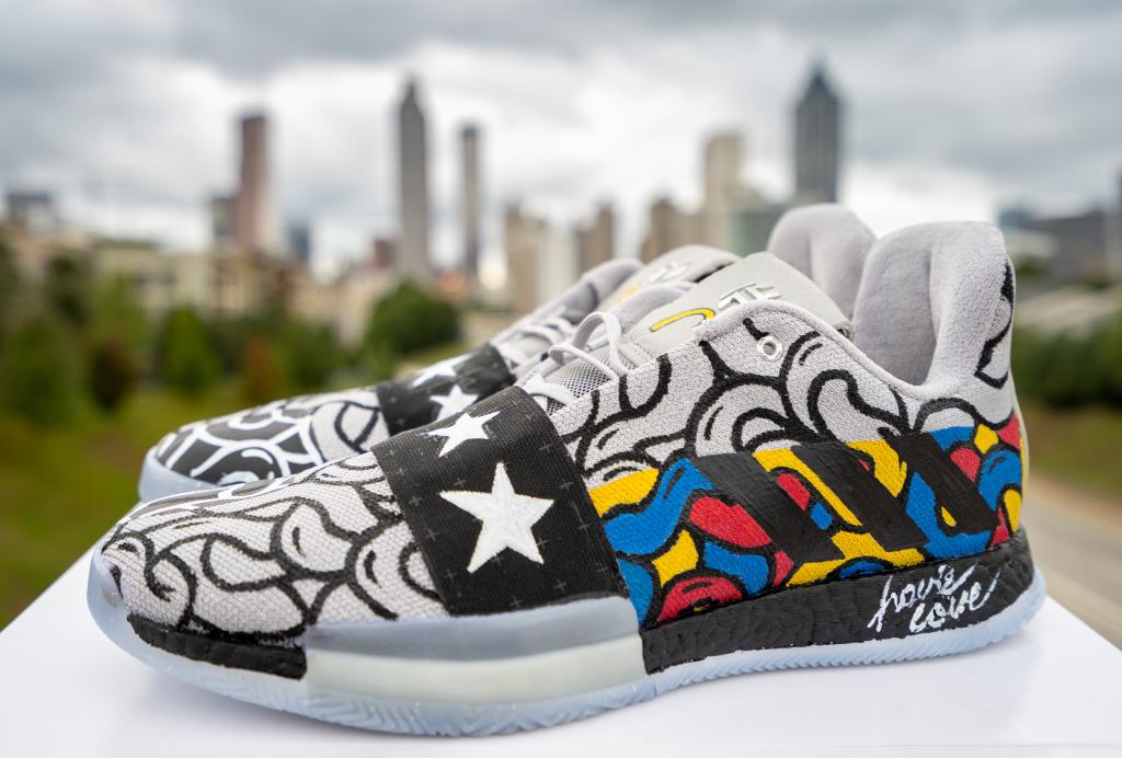 Image of custom painted adidas shoes in front of faded Atlanta skyline