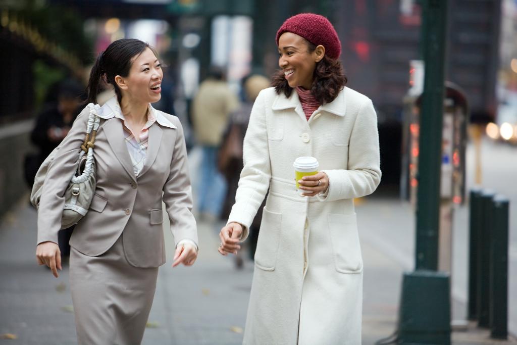 Two women walking in a city. 
