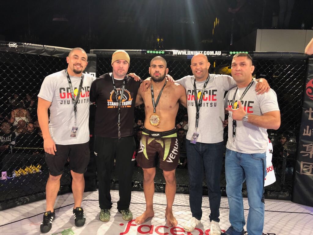 Robert Whittaker celebrates teammate Jacob Malkoun's victory alongside his coaches