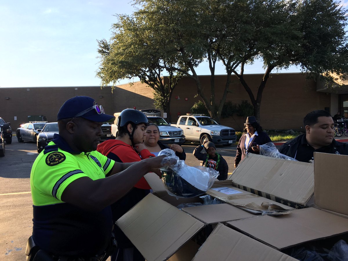 DPDCA's tweet photo. Officer Varner is helping kids get right bike helmet so they can stay #safe riding their bikes at the #ROCing RedBird event. #safetyfirst @DPDCA @DPDUnidos @DallasPD https://t.co/6bzj2hELzt