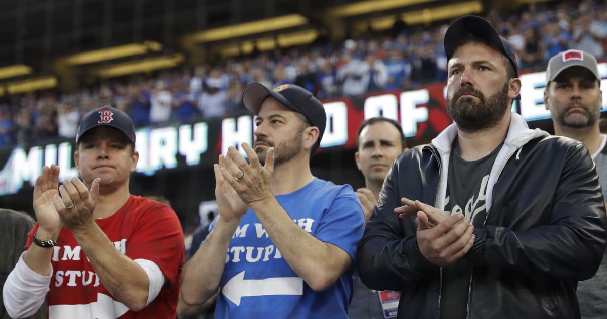 Matt Damon, Jimmy Kimmel and Ben Affleck at Game 5 of the World Series. Damon and Kimmel are each wearing "I'm With Stupid" shirts with arrows pointing at one another.
