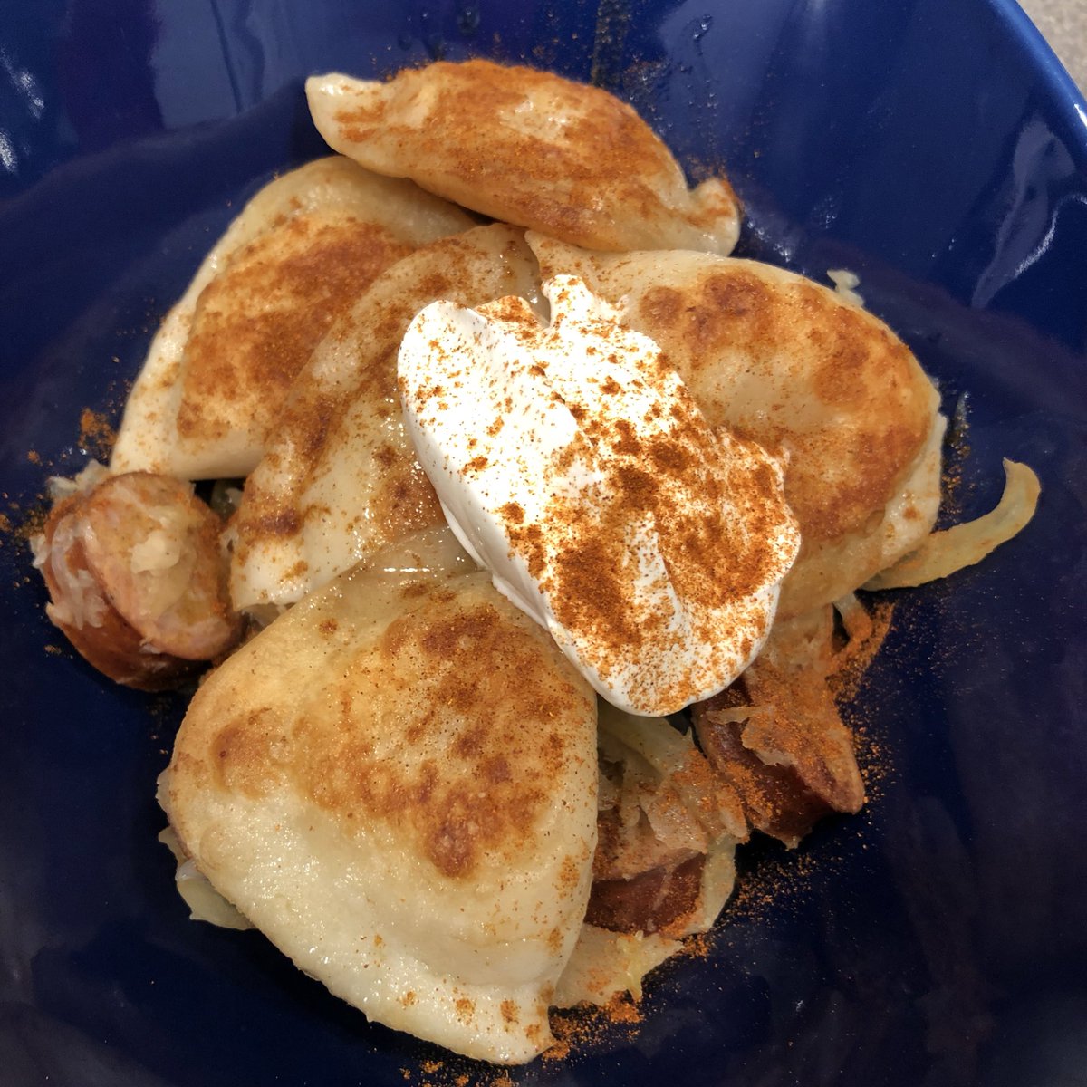 InfoSecSherpa's tweet image. Potato and cheese Pierogi on a bed of sauerkraut, sautéed onions, and turkey kielbasa. Dollop of sour cream and paprika for garnish.