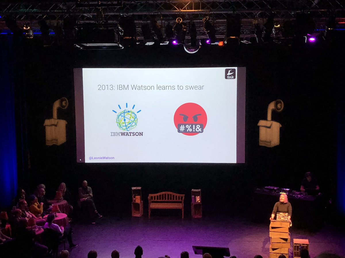 On the right side of the photo is Léonie Watson as she is presenting her talk on the stage of Beyond Tellerrand. In the middle, a slide from her talk showing an example of the IBM Watson super computer.