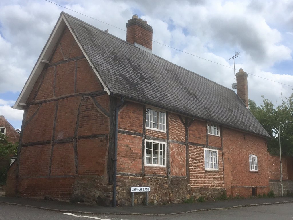 Timber framed and brick cottage on a stone plinth. The steep pitch (slope) of the slate roof suggests it was once thatched. Thrussington, Leicestershire.
