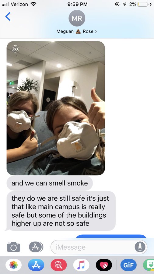 Text messages from a Pepperdine student whom had to evacuate to their cafeteria & says she can smell smoke. Included: photo of 2 college girls wearing medical masks
