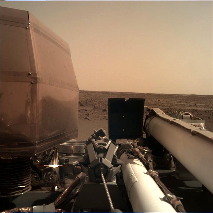 Image of Mars with lander arm and instrument visible