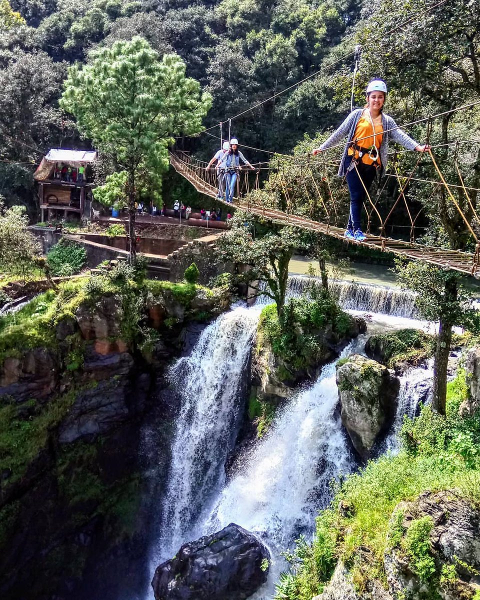 Visitantes caminando por el puente colgante en Quetzalapan