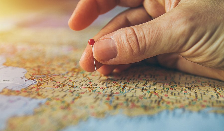 a person putting a pin onto a map of the world