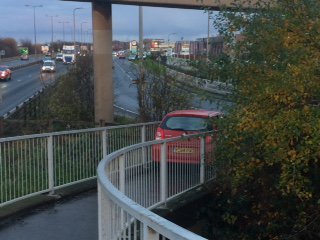 RadioHumberside's tweet image. This car has managed to drive down a footpath over the A63 and wedge itself at the bottom. Police have come to their rescue in Hessle.