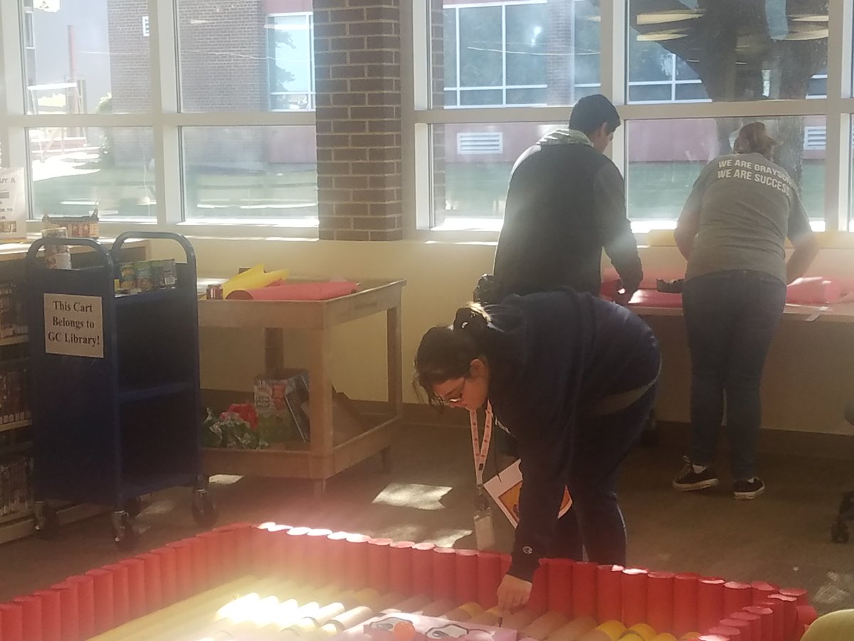 GraysonLibrary's tweet photo. Staff, and students working diligently on the Canstruction project. Can you tell what it is going to be? #Canstruction2018 https://t.co/1JaTy2ZPG1