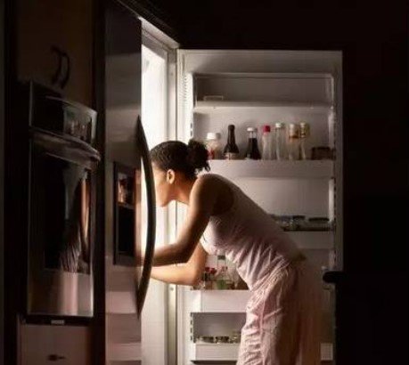 Чем плохо есть на ночь. Девушка у холодильника. Человек у холодильника ночью. Заглядывает в холодильник. Девушка возле холодильника.