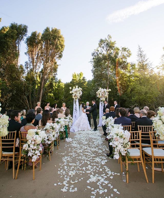 PartySlate's tweet photo. A petal covered aisle, lined with lush bouquets, leads to the ceremony space with matching florals and simple white drapery. This grand forrest backdrop is both romantic and stunning. || Photographer: @augiechang | Planner: @amazaeevents || #PartySlate #PartySlatePro https://t.co/C2BzvY2q6L