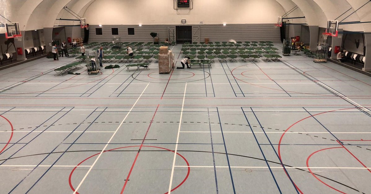 RodeKruis's tweet photo. Het wordt een erg koude nacht vannacht en dus gaat de #winterkouderegeling van start. Mensen van ons burgerhulpnetwerk @Ready2Help_NL zetten bedden neer in een sporthal in Amsterdam-Noord, voor de opvang van 120 daklozen. https://t.co/19uoqaOGr3