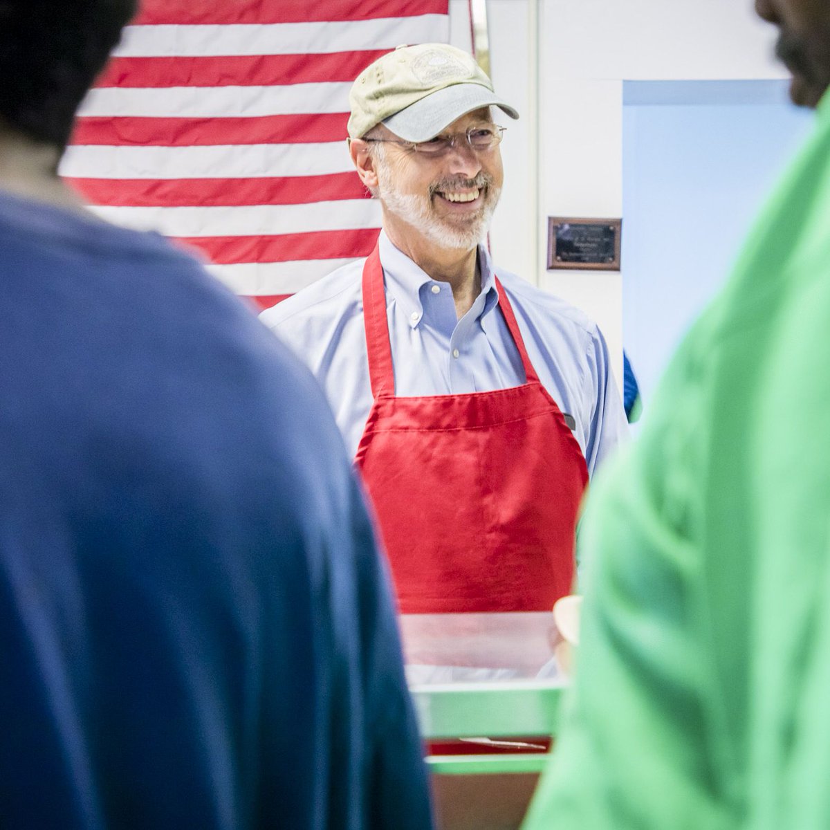 Phoyo of Governor Wolf wearing red apron and smiling 