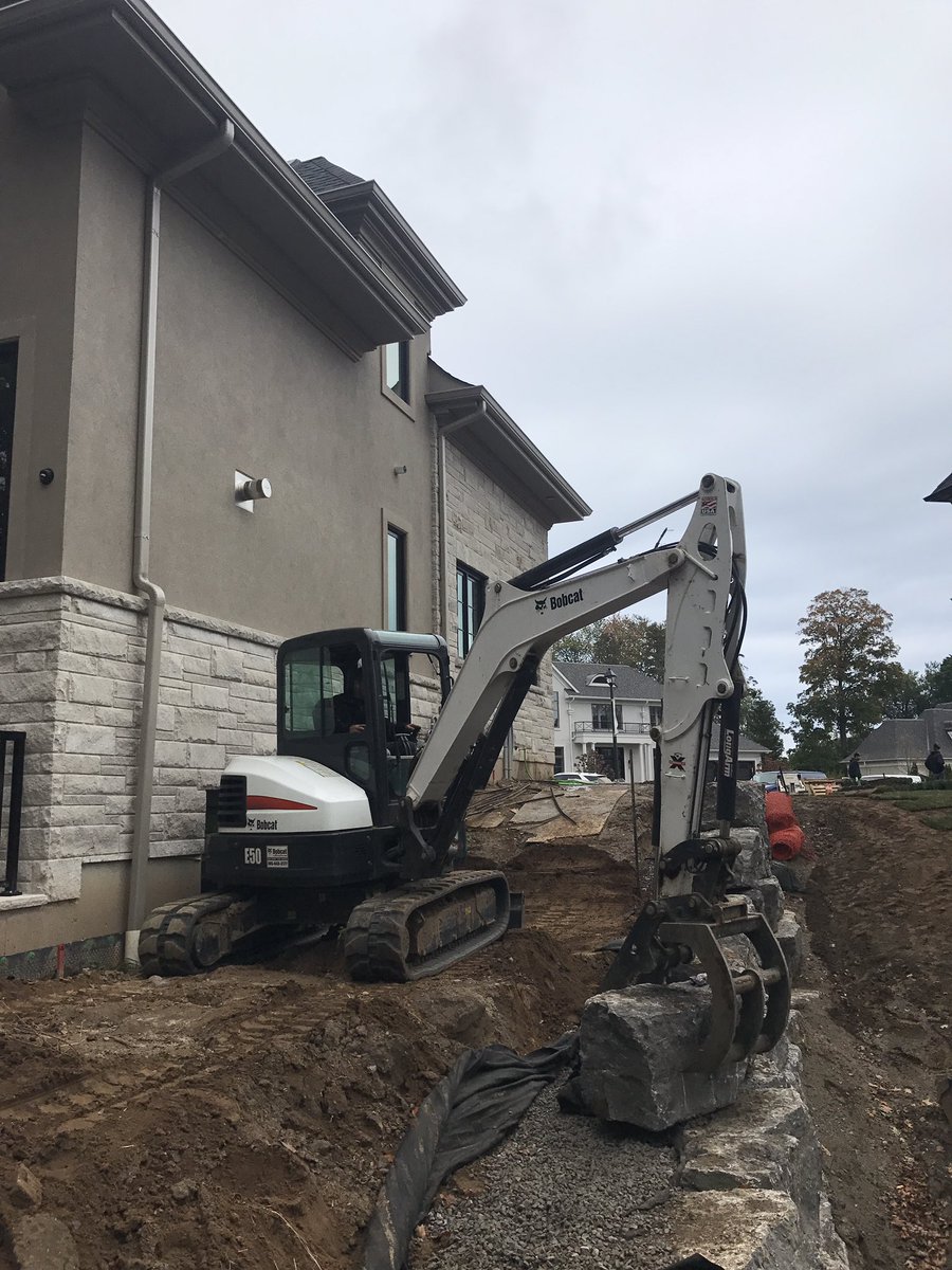 Nothing quite like natural stone retaining walls! #ArmourStone #RetainingWall #e50 #bobcat