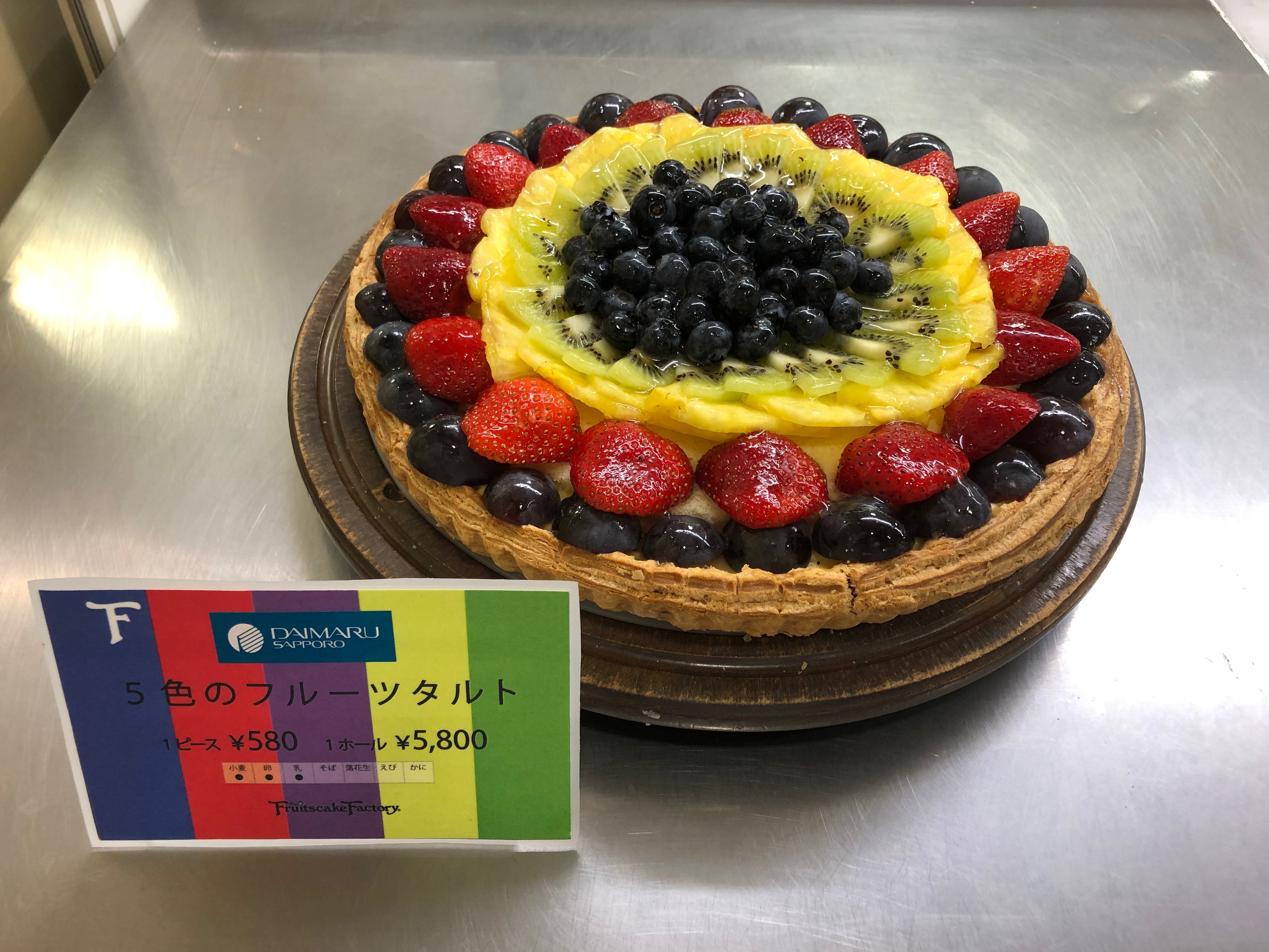 大丸札幌店 デパ地下トピックス フルーツケーキファクトリーから彩り鮮やかなタルトのご案内 ぶどう 苺 パイナップル キウイ ブルーベリーがのったフルーツたっぷりの ５色のフルーツタルト １ピース580円 1ホール5800円 いずれも税込み