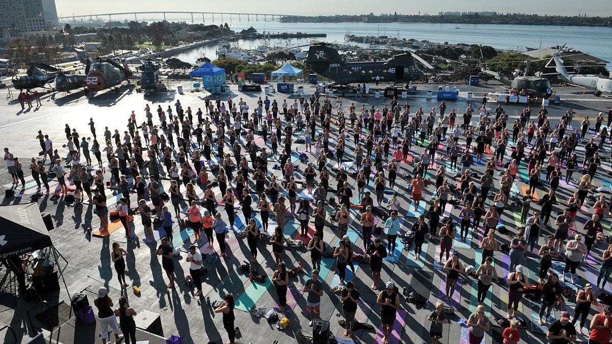PacificSD's tweet photo. SPOTTED: Yogis at Sweat for Service experienced a dynamic yoga session aboard the @USSMidwayMuseum to raise funds for the families of fallen soldiers | Pics by #RickNocon | More here: https://t.co/tQ1qus75ee https://t.co/VFdpTSNh7V