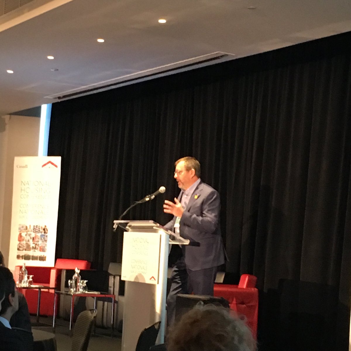 LoriAnnGirvan's tweet photo. Derek Ballantine, chair @CMHC_ca opening day 2 of the National Housing Conference: we need to use all of our talent, creativity and financial tools to achieve housing affordability for all Canadians by 2030. #ParlonsLogement #HousingWeek2018 https://t.co/MEzCGzAgYQ