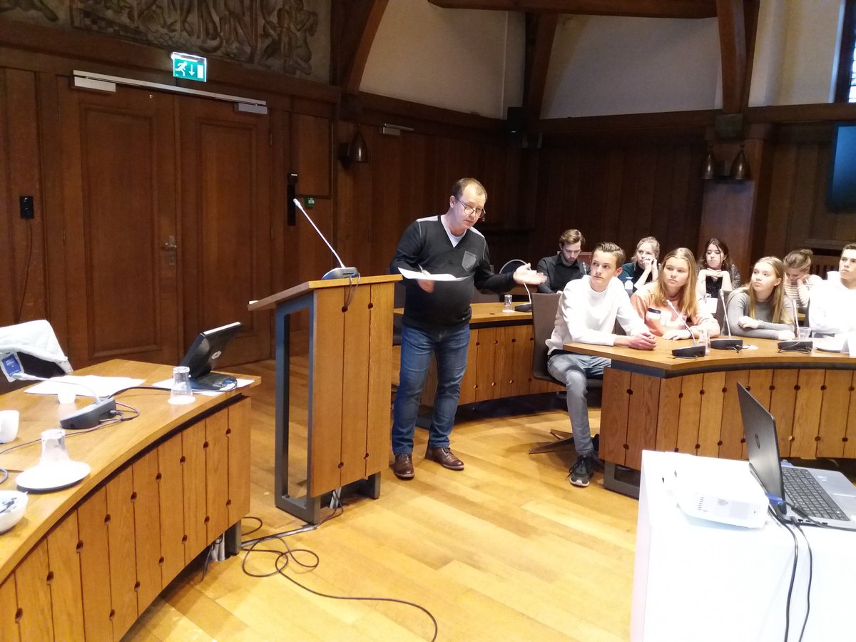RaadBreda's tweet photo. Sociaal #wijkmanager Angelo Gommeren vertelt 5 vwo leerlingen over het verbinden van groepen, de heuvel community en de oasisgame. #jeugdenpolitiek #leren  #breda https://t.co/ggy0A6cE1y