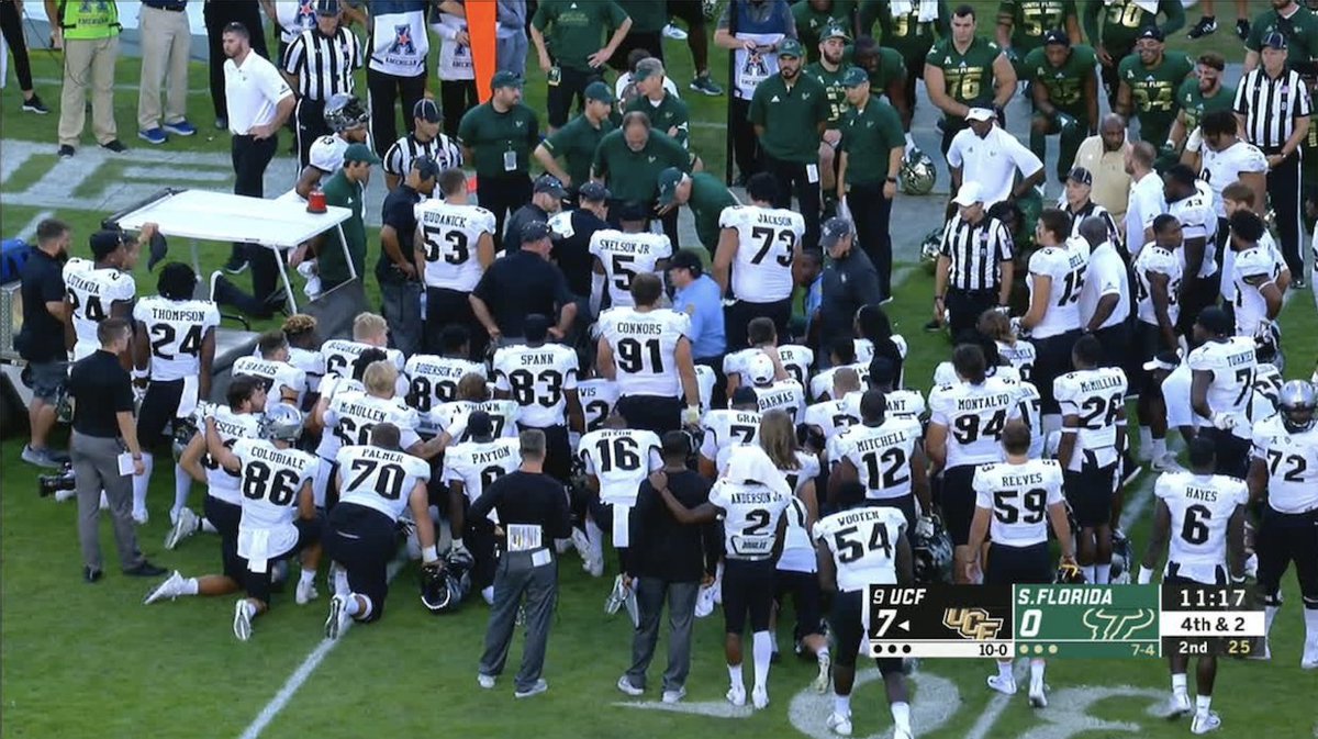 ESPNCFB's tweet photo. After McKenzie Milton went down with a gruesome leg injury in Tampa, players on both teams were on a knee as he was casted up and carted off the field 🙏 https://t.co/w32GAsoxqK