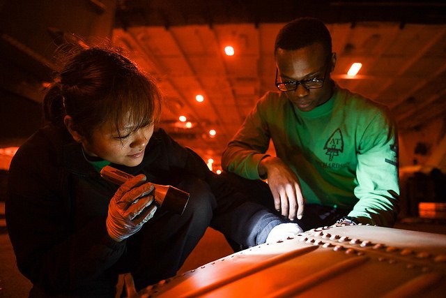 USNavyEurope's tweet photo. Sailors assigned to the “Proud Warriors” of Helicopter Maritime Strike Squadron #HSM72, conduct an inspection on an MH-60R Seahawk helicopter part in the hangar bay aboard the @USSHARRYSTRUMAN. https://t.co/dAlS76kpJI
