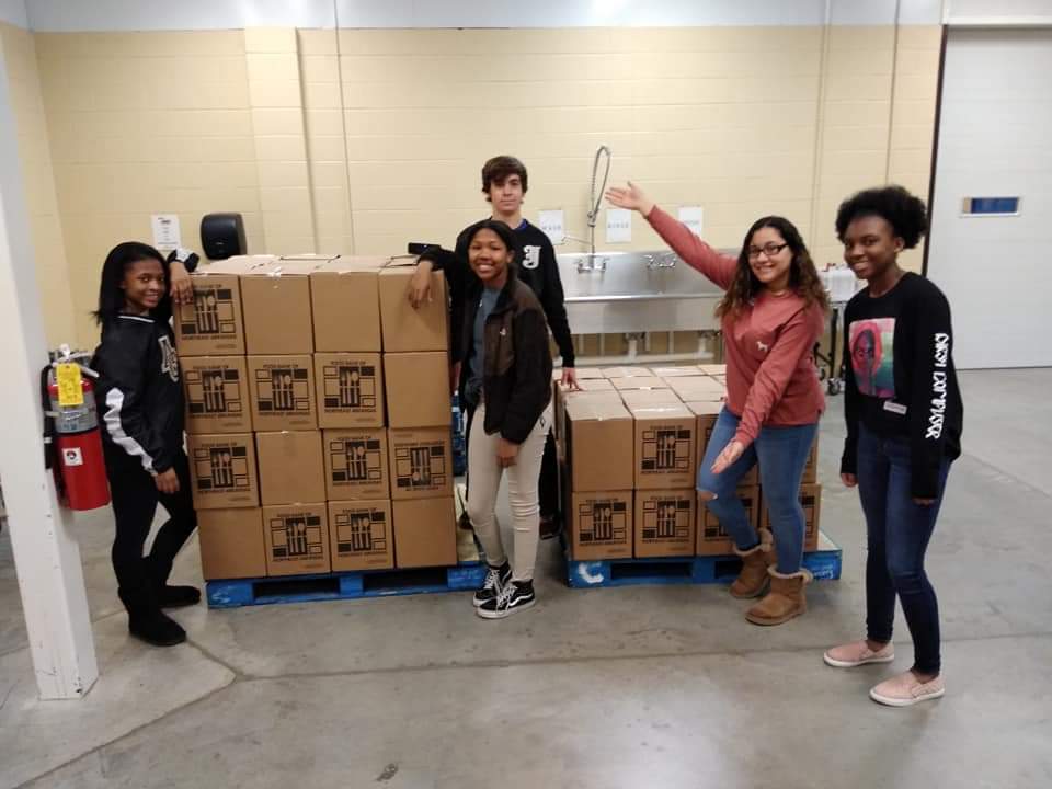 ACWhirlwinds's tweet photo. Members of the Annie Camp Student Action Committee volunteered at the Food Bank of North East Arkansas. These students sorted and packed 96 boxes (just over 2,300 cans), filling a pallet and a half in just 2 hours! #whirlwindnation #caneclassroom #ACSAC #giveback #acjhs #weareAC https://t.co/N5wYZOo58p