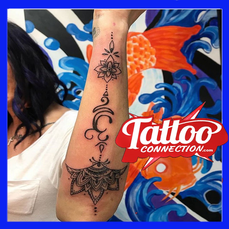 Om!  Lotus tattoo design gracing Dina's arm. #SpiritualTattoos #TattooedWomen