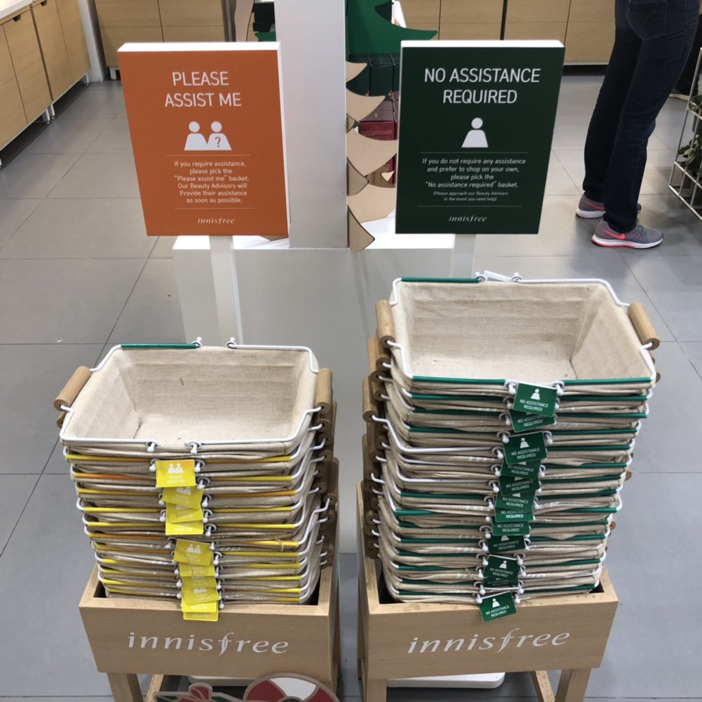 two stacks of baskets. one is labeled "please assist me" and the other is labeled "no assistance required"