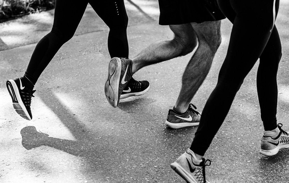 Legs of three people jogging away: Photo by aquachara on Unsplash