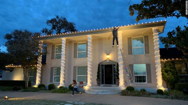 A figure hangs from a house, unable to reach a fallen ladder, in a scene that led to panicked 911 calls. One good Samaritan stopped his car and ran to help the man, only to find a Clark Griswold dummy in a "Christmas Vacation" holiday lights display. cnn.it/2EdoHFQ