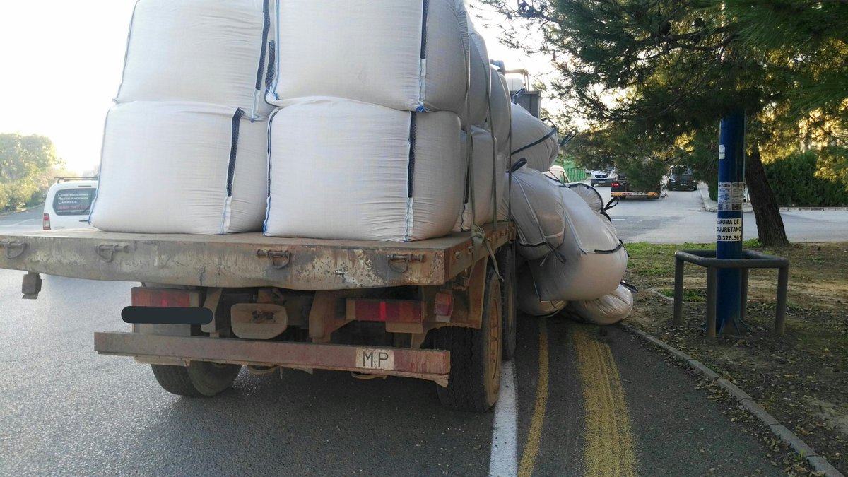 PoliciaCarmona's tweet photo. @PoliciaCarmona y bomberos restablecen el tráfico en la glorieta de la avenida Bonifacio IV tras la caída de la carga de un camión el cual carecía de autorización para realizar el transporte de la misma y de itv. Se inmoviliza el vehículo. https://t.co/Mamn60ha81
