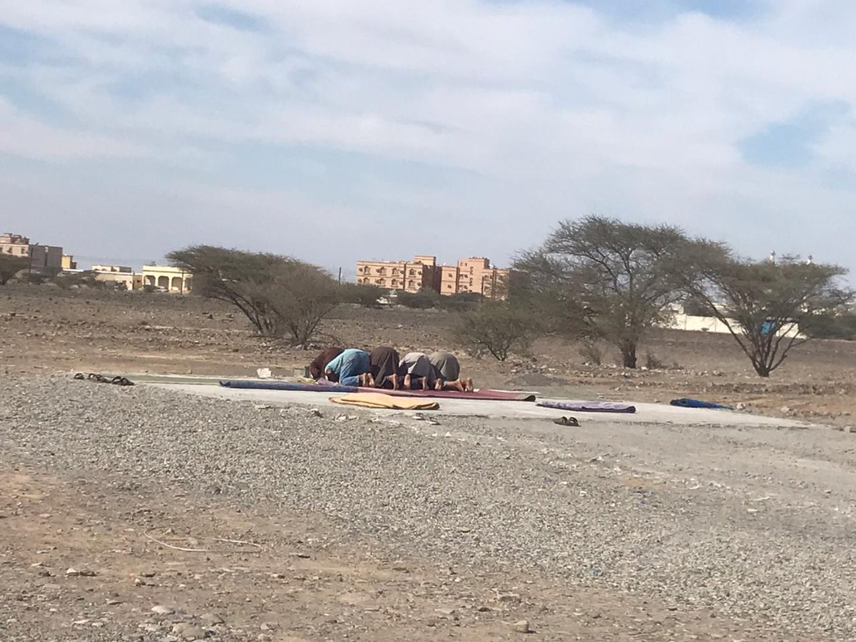 مشهد لعمال المنطقة الصناعية بولاية #الخابورة وهم يأدون الصلاة تحت أشعة الشمس بعد ما تم إزالة المصليات بالصناعية من قبل لجنة الإزالة ببلديات شمال الباطنة.