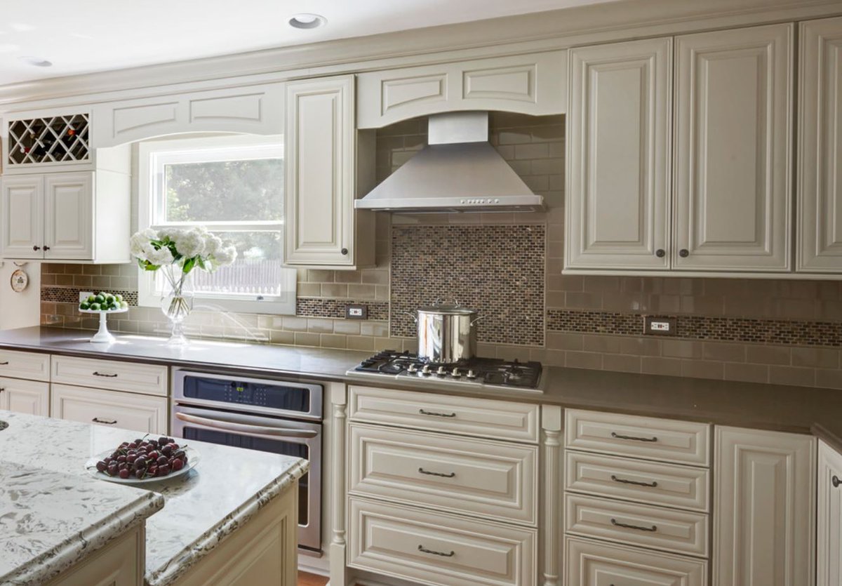 #TraditionalKitchen in #Deerfield: The kitchen's focal point is the cook top and stainless steel hood, accented by turnings, decorative valance and mosaic back splash tile.