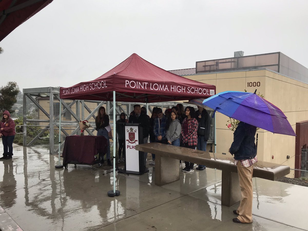 ptlomahs's tweet photo. Even a damp day couldn’t stop friends from coming out to dedicate our campus memorial to our beloved Kevin Gormly. His bench overlooks the ocean and our football field, two places he loved. #lovesdschools #Pointerway https://t.co/KswKeKQsp7