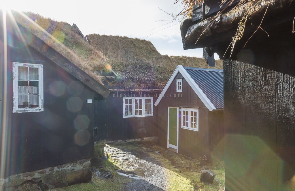 Contrast with this image of a lone corrugated tin roof among a group of sod roofs: the metal roof looks out of place. If it was the other way around, the lone sod roof would blend in.