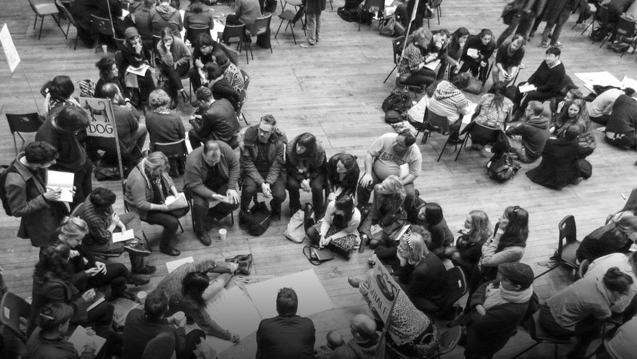 Black and White photo of people sitting in large circles in discussion at a D&D event.