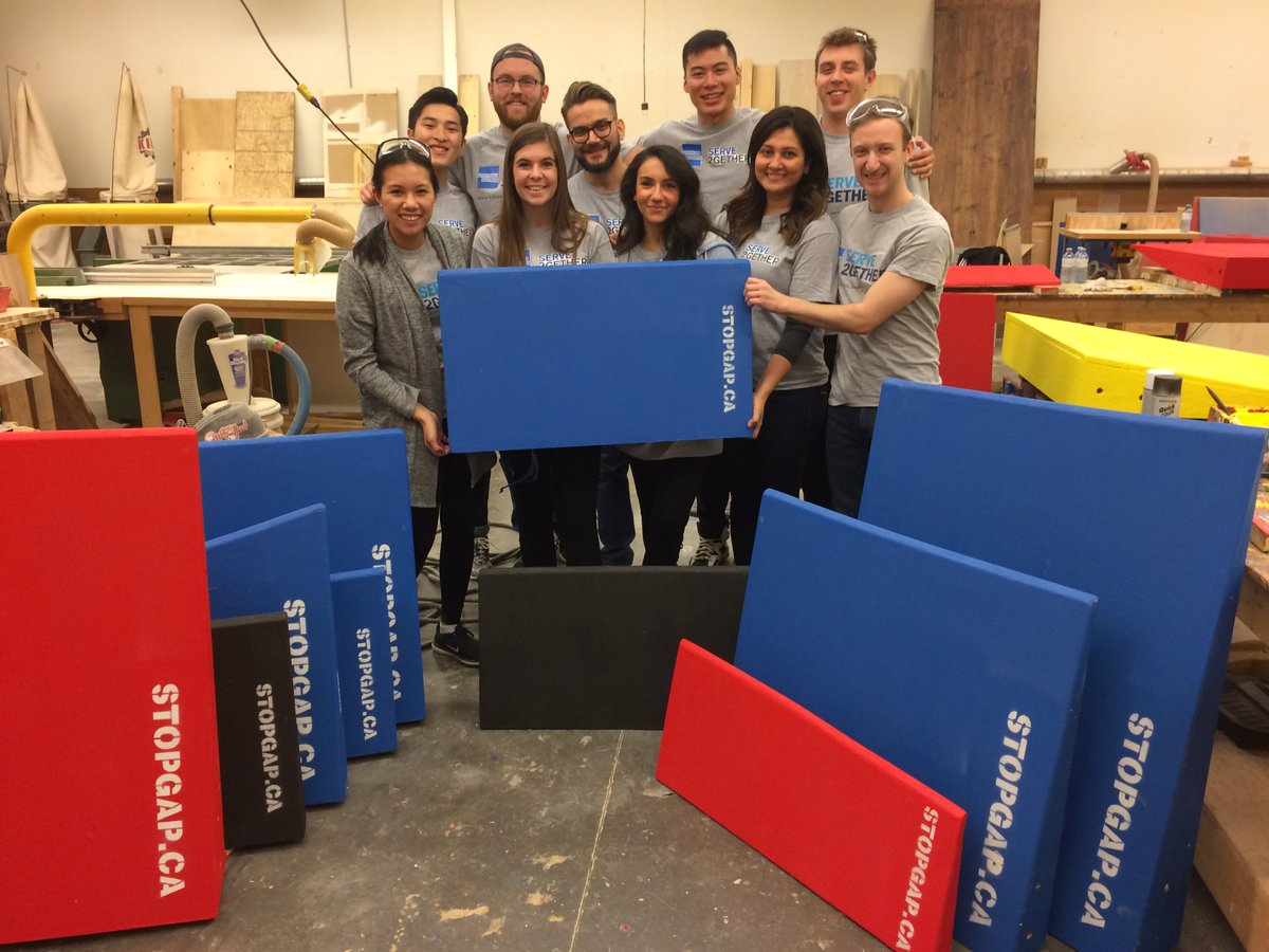 Team members from American Express smile beside many brightly coloured StopGap ramps.