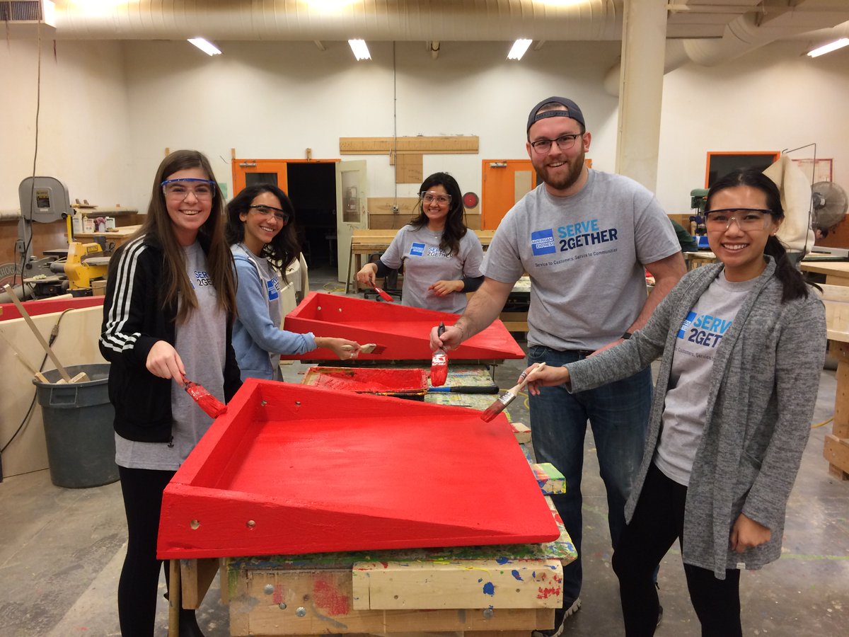 Team members from American Express paint red StopGap ramps.