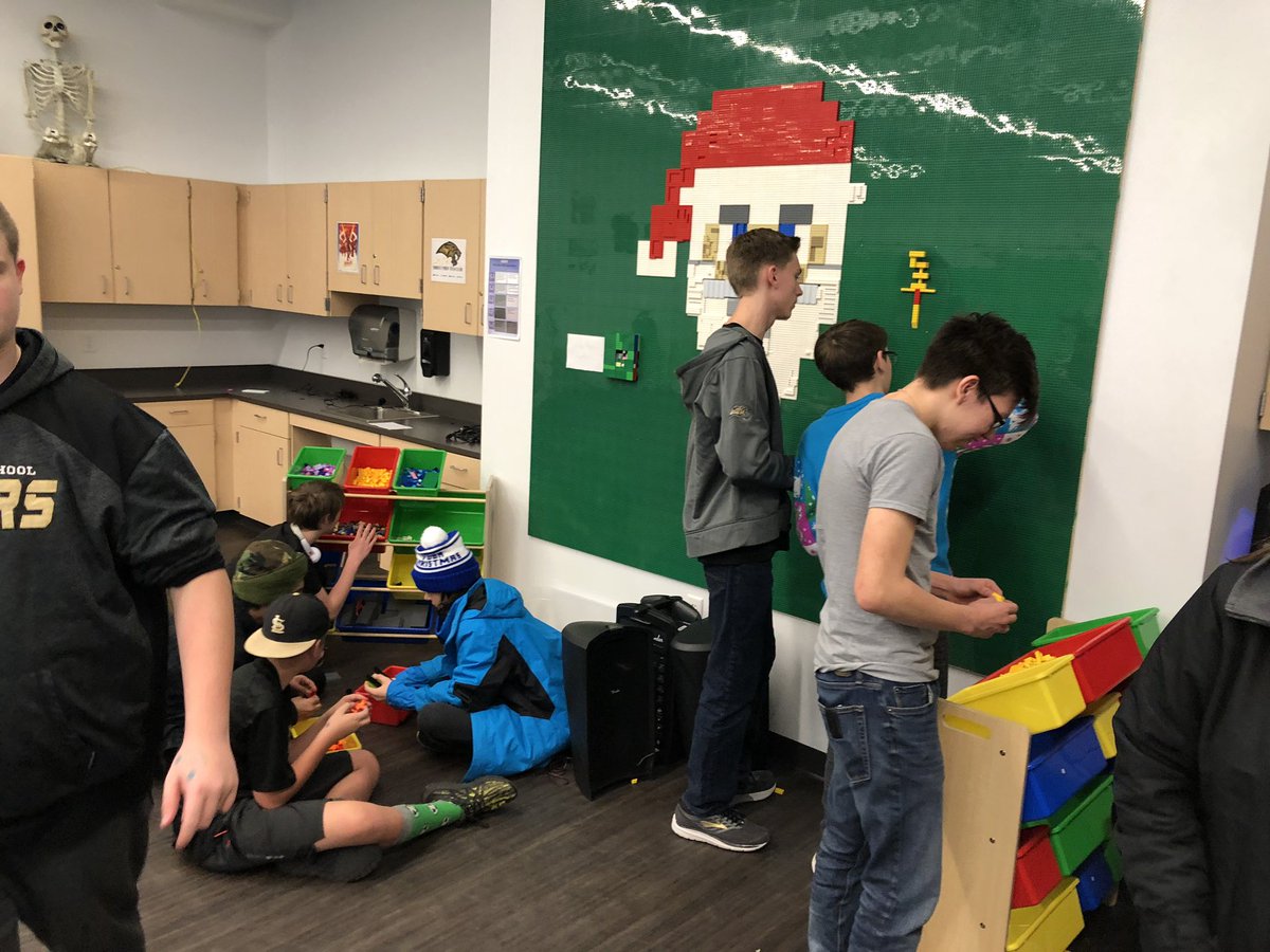 MJJacobson's tweet photo. People hard at work in the Legacy Cyber Hub with their Maker-space holiday hub! LEGO wall, Buttons, LED gift tags, Breakout EDU, Ornaments! #learnbps, #ndlibchat https://t.co/tiOA2RxLuJ