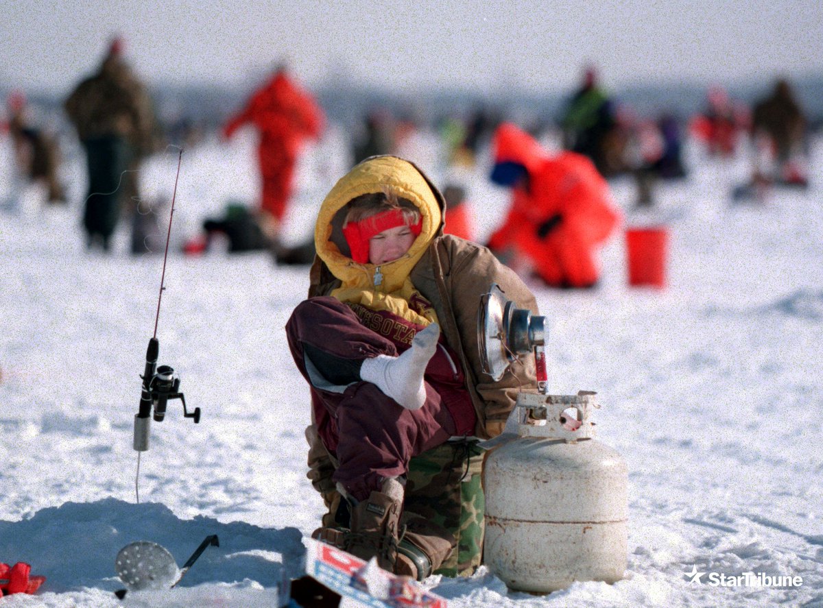 J.W. Armstrong, 11, of Cottage Grove, warms his feet while competing in the Golden Rainbow ice fishing contest on Sunday, Feb. 4, 1996 at Forest Lake. (@jerry_holt/@StarTribune)