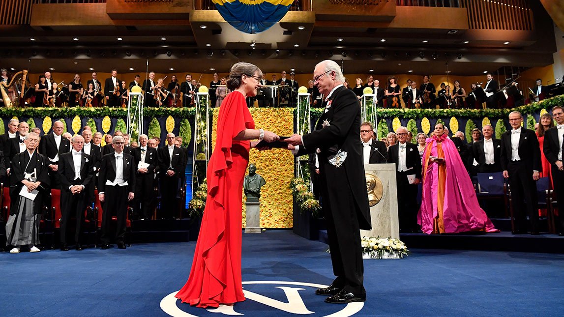 Donna Strickland receiving her Nobel Prize from King Carl Gustav of Sweden before a host of laureates and dignitaries