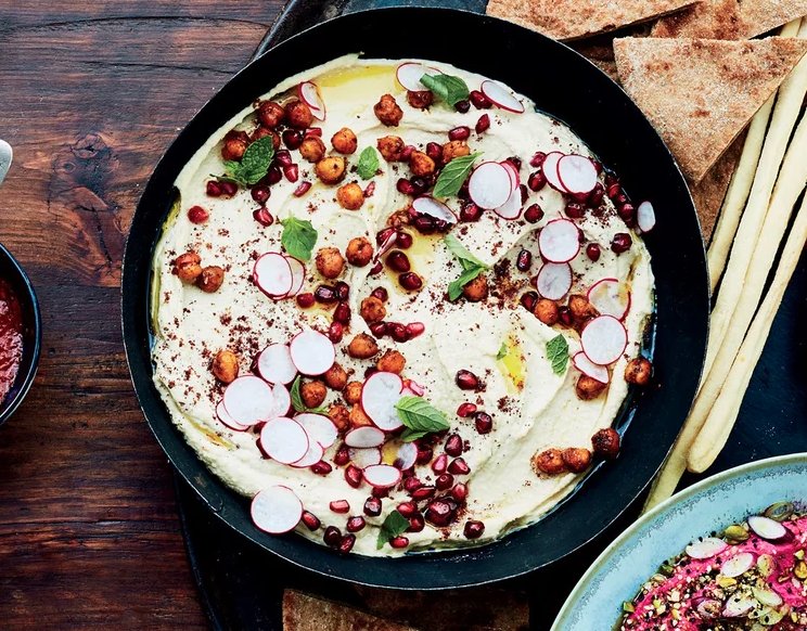 Homemade hummus gets a delightful textural contrast when you serve it with a few elegant garnishes.
Try pomegranate seeds, roasted chickpeas, fresh mint, and radish slices: https://goo.gl/eMO9FV